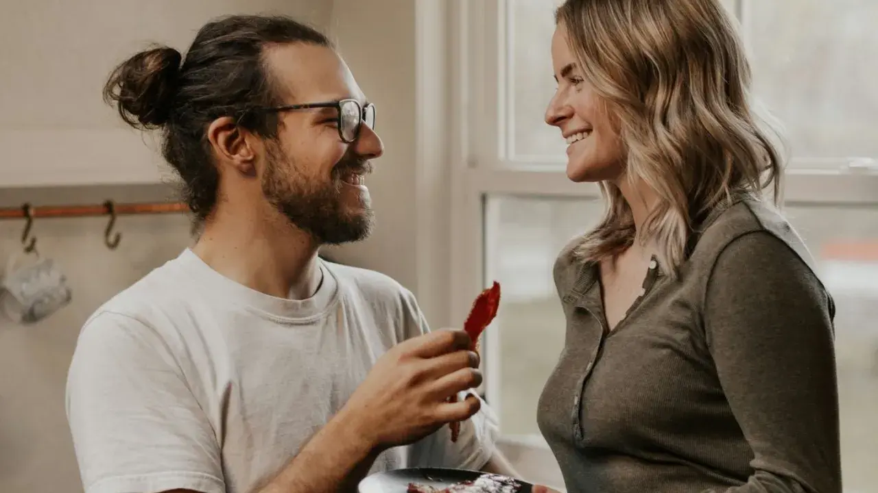 Un homme aux lunettes offre une tranche de bacon à une femme souriante. Une scène qui pourrait être le début d'une belle histoire, ou juste une définition de la friendzone.