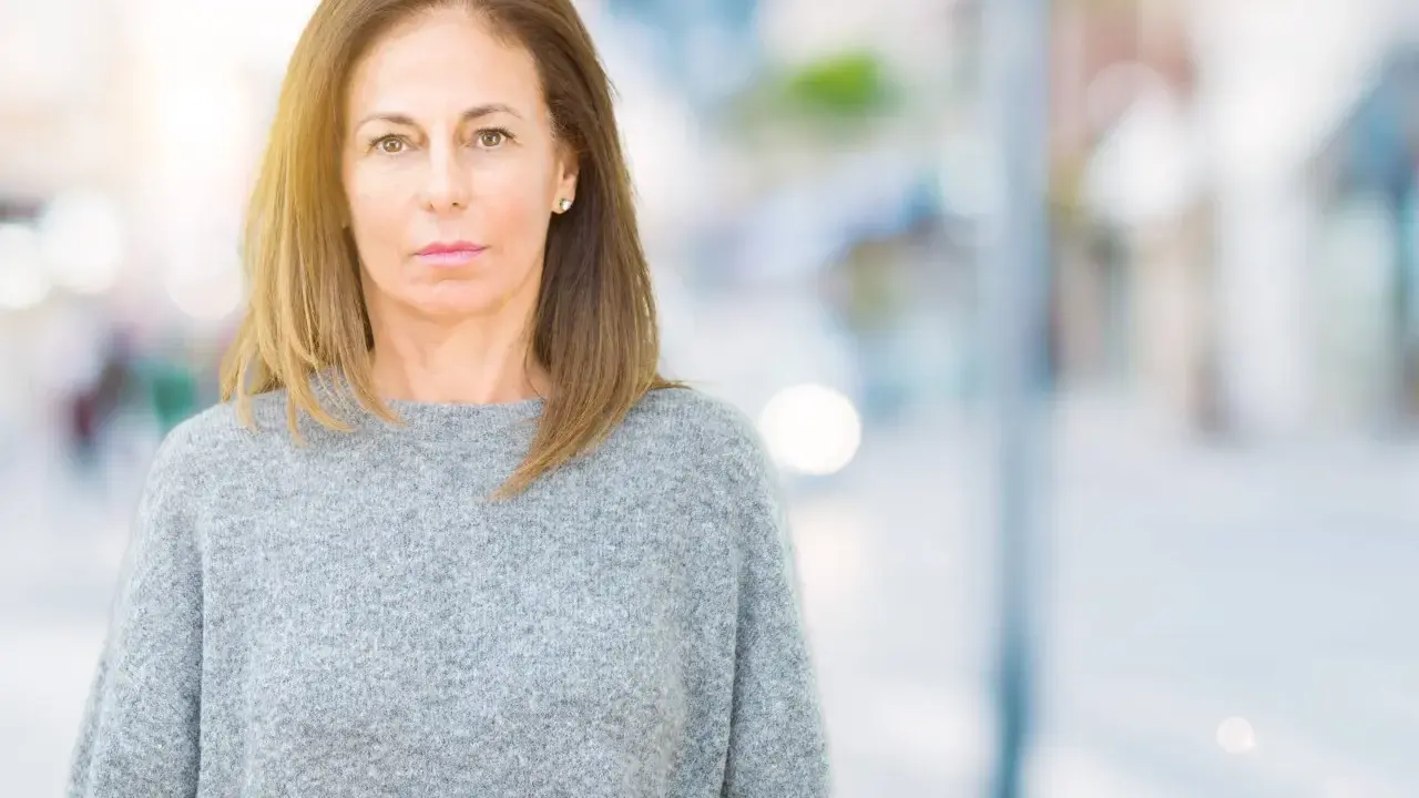 Portrait d'une femme d'âge mûr, regardant fixement, évoquant la psychologie du renarcissisme.