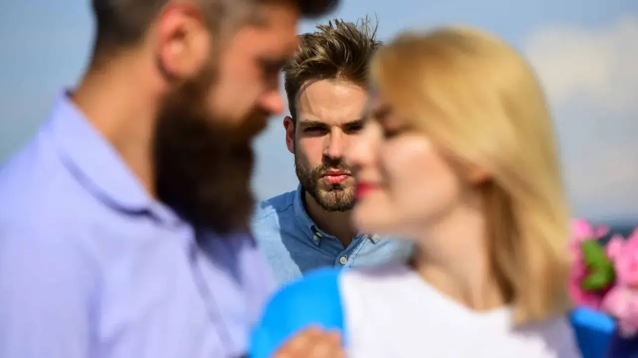 Un homme regarde intensément un couple. Il semble que mon ex PN a refait sa vie, et il est là, observant.