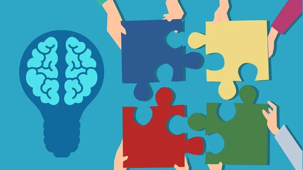 Des mains assemblent des pièces de puzzle autour d'une ampoule représentant un cerveau, symbolisant la compréhension de la déficience mentale légère chez l'adulte.