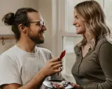 Un homme aux lunettes offre une tranche de bacon à une femme souriante. Une scène qui pourrait être le début d'une belle histoire, ou juste une définition de la friendzone.