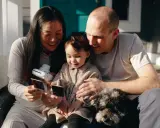 Famille heureuse regardant des photos instantanées, une annonce grossesse fratrie en préparation.
