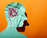 Silhouette d'une tête en papier froissé, avec un fil rouge emmêlé symbolisant la pensée complexe d'un esprit hpi neuroatypique.