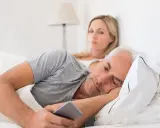 Un homme, absorbé par son téléphone, ignore sa femme. Les signes d'un homme amoureux de sa maîtresse sont subtils, mais son regard ailleurs en dit long.