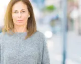 Portrait d'une femme d'âge mûr, regardant fixement, évoquant la psychologie du renarcissisme.