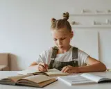 Jeune fille concentrée sur son cahier, peut-être en pleine préparation d'un test HPI WISC.