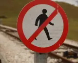 Panneau interdisant le passage aux piétons près des voies ferrées. Il me débloque sans me parler, me rappelant la prudence.
