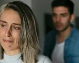 Une femme au regard triste, un homme flou en arrière-plan. Pourquoi un homme cache qu'il a une copine ? Une situation compliquée.