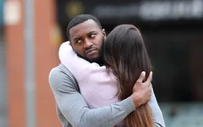 Un homme étreint une femme, mais son regard trahit une préoccupation. Comment savoir s'il pense à moi ?