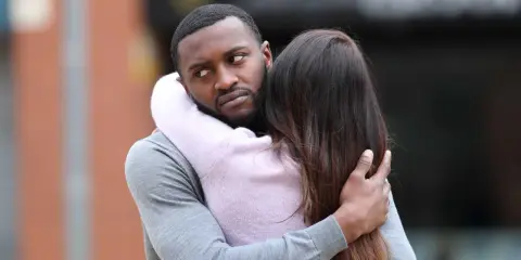 Un homme étreint une femme, mais son regard trahit une préoccupation. Comment savoir s'il pense à moi ?