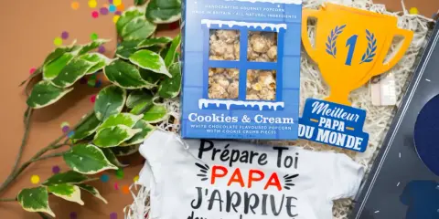 Un petit mot pour futur papa : un body "Papa j'arrive" et du popcorn pour célébrer l'heureux événement.