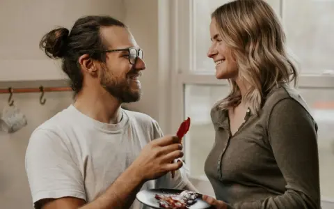 Un homme aux lunettes offre une tranche de bacon à une femme souriante. Une scène qui pourrait être le début d'une belle histoire, ou juste une définition de la friendzone.