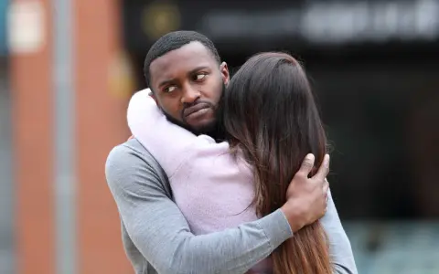 Un homme étreint une femme, mais son regard trahit une préoccupation. Comment savoir s'il pense à moi ?