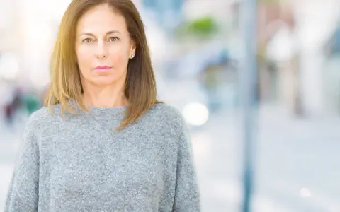 Portrait d'une femme d'âge mûr, regardant fixement, évoquant la psychologie du renarcissisme.