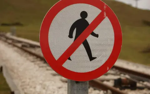 Panneau interdisant le passage aux piétons près des voies ferrées. Il me débloque sans me parler, me rappelant la prudence.