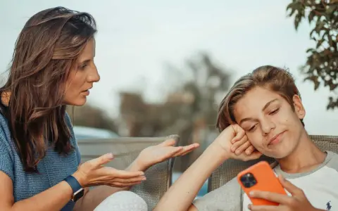 Une mère parle à son fils, qui semble désintéressé, son téléphone à la main. Un test schizoïde pourrait évaluer ce type de déconnexion.