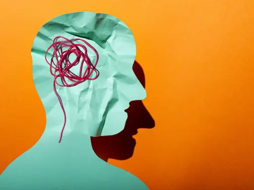 Silhouette d'une tête en papier froissé, avec un fil rouge emmêlé symbolisant la pensée complexe d'un esprit hpi neuroatypique.