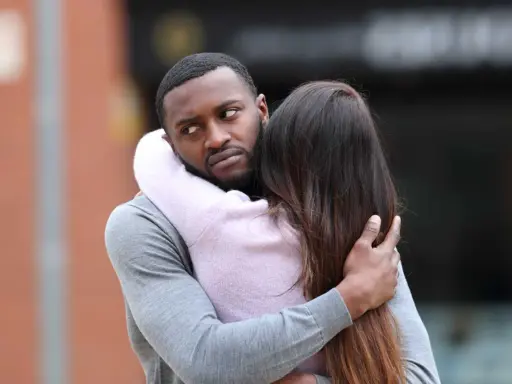 Un homme étreint une femme, mais son regard trahit une préoccupation. Comment savoir s'il pense à moi ?