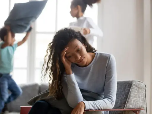 Une mère épuisée, tandis que ses enfants s'amusent à se battre avec des oreillers. Comment faire pour eduquer sans s'épuiser ?