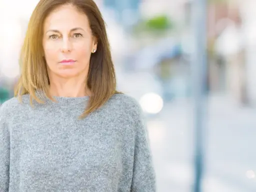 Portrait d'une femme d'âge mûr, regardant fixement, évoquant la psychologie du renarcissisme.