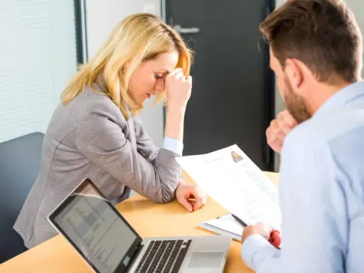 Une femme stressée lors d'un entretien d'embauche, face à un recruteur qui examine son CV. Un test pour déceler un pervers narcissique au travail.