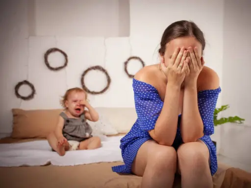 Une mère désespérée cache son visage, son bébé pleure. Je ne supporte plus ma vie de famille.