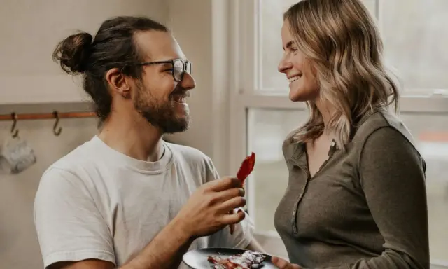 Un homme aux lunettes offre une tranche de bacon à une femme souriante. Une scène qui pourrait être le début d'une belle histoire, ou juste une définition de la friendzone.