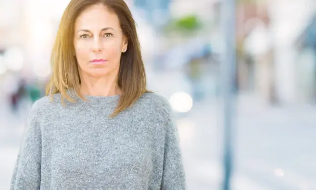 Portrait d'une femme d'âge mûr, regardant fixement, évoquant la psychologie du renarcissisme.