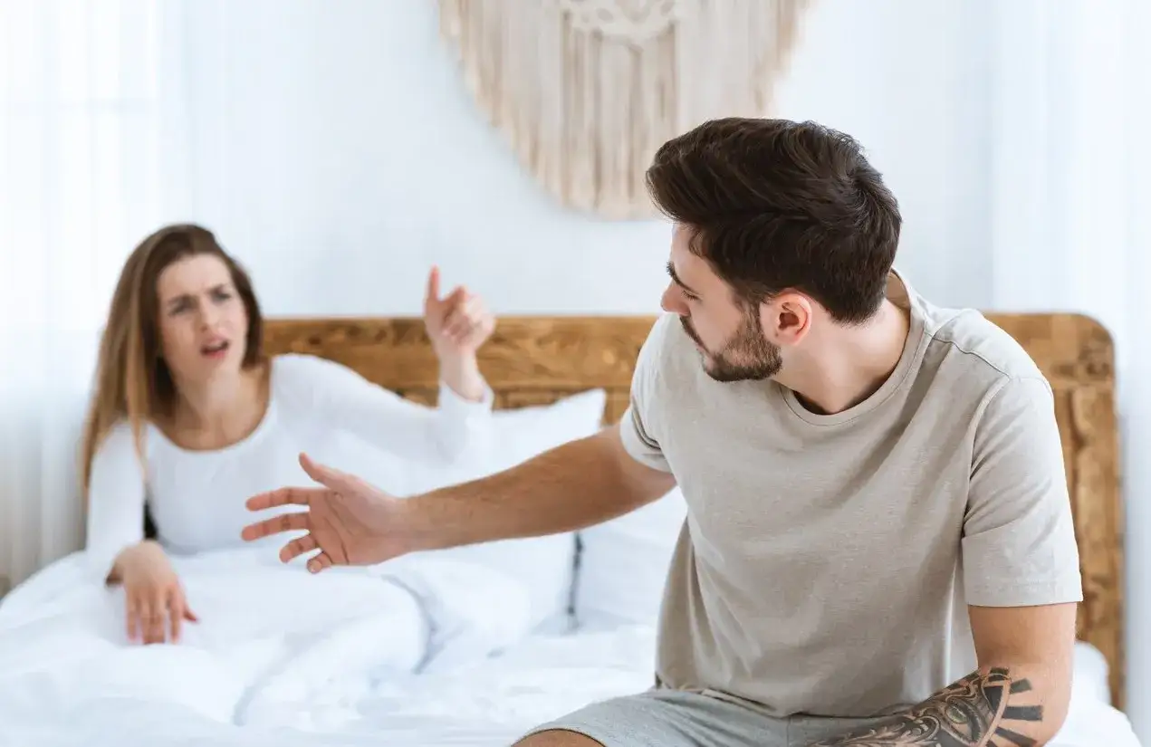 Une femme en détresse dans un lit, se sentant seule car mon mari ne me soutient pas pendant grossesse. Il détourne le regard.