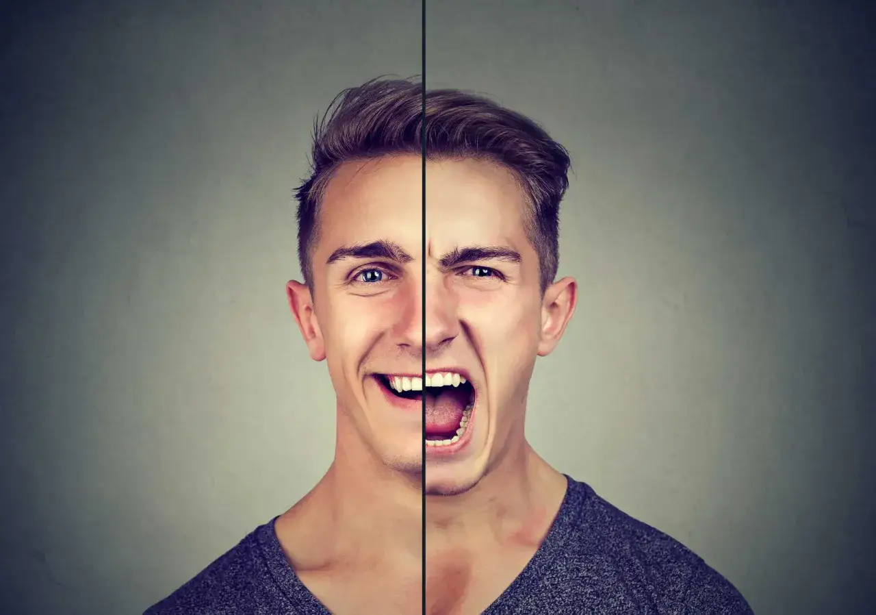 Visage d'un homme divisé : un côté souriant, l'autre criant. Illustration de la psychologie de souffler le chaud et le froid.