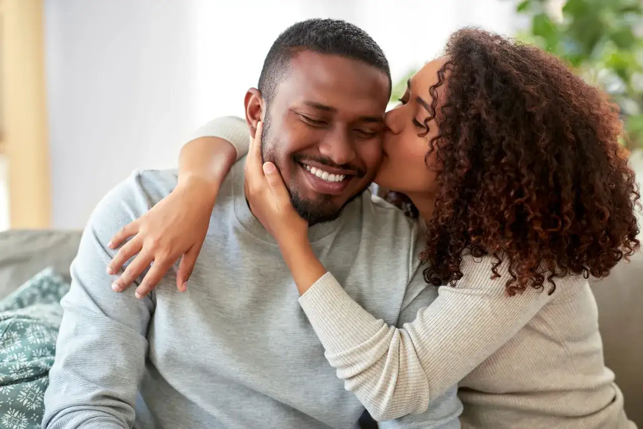Une femme embrasse tendrement un homme souriant. Un moment de complicit&eacute; qui aide &agrave; savoir si un homme est sinc&egrave;re.