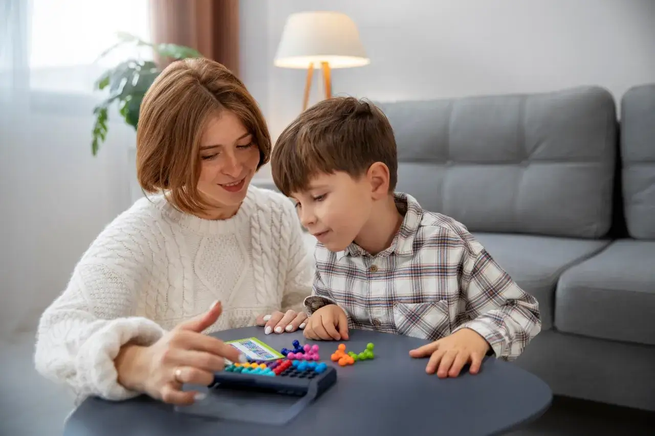 Une mère et son fils jouent à un jeu de réflexion coloré, le wppsi iv est un excellent outil pour évaluer les capacités cognitives.