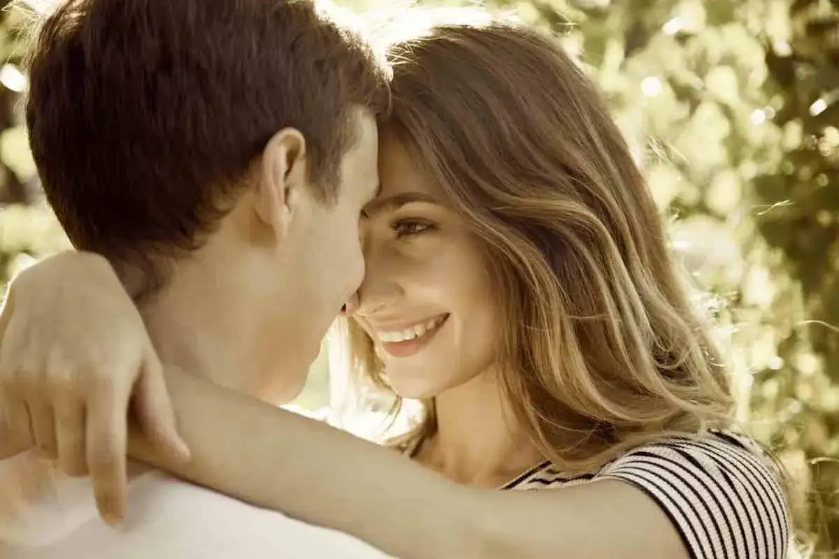 Un jeune couple s'embrasse tendrement, leurs fronts se touchant. Un sourire radieux illumine le visage de la jeune femme, annon&ccedil;ant le d&eacute;but d'une histoire d'amour.