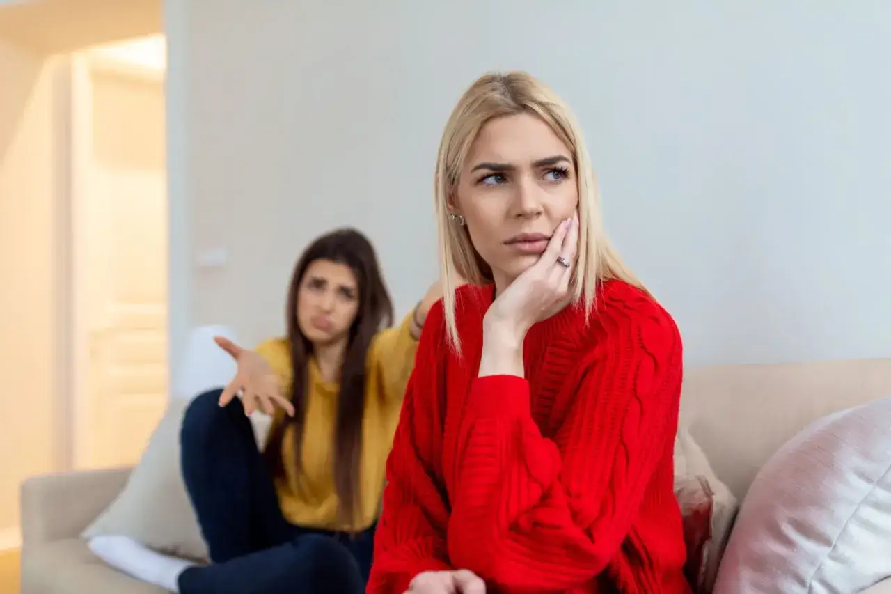 Deux femmes sur un canap&eacute;, l'une pensant &agrave; comment d&eacute;stabiliser un s&eacute;ducteur, l'autre visiblement contrari&eacute;e.