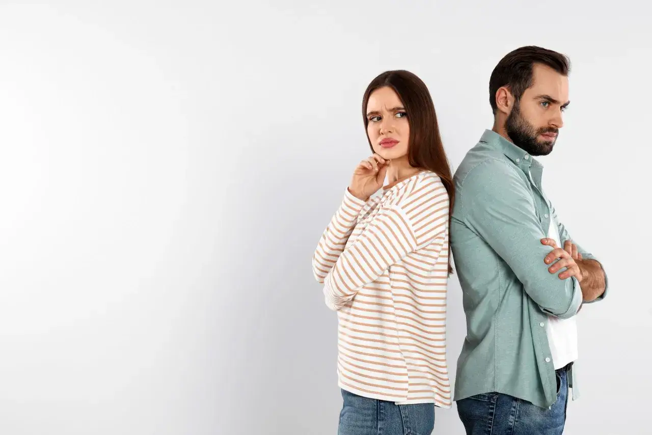 Un couple se tourne le dos, l'air contrari&eacute;. Elle semble d&eacute;&ccedil;ue, lui distant. Une sc&egrave;ne qui &eacute;voque le sentiment de ghoster quelqu'un qu'on aime.